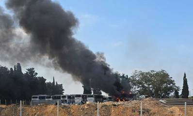 נפילת טיל בהרצליה. עשן שחור מיתמר ממקום הנפילה, ליד חניון של אוטובוסים.