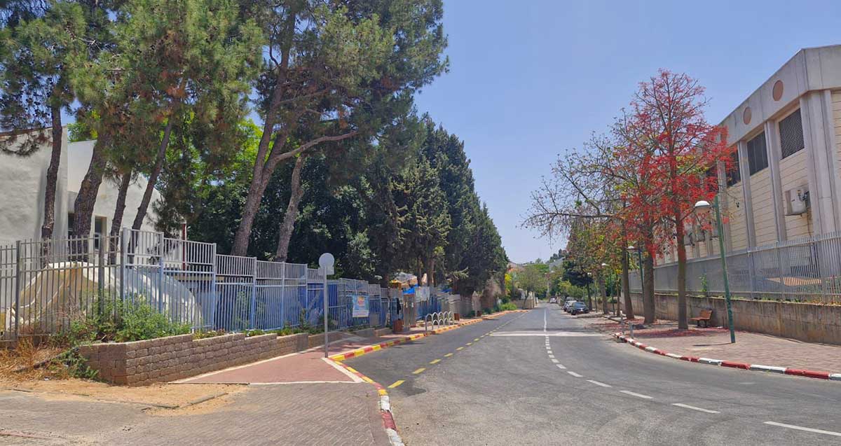 בית הספר של חב"ד בשכונת סביוני הכפר בכפר סבא. כביש במרכז התמונה. מימין לכביש מבנה של שתי קומות, ומשמאל לכביש מבנה המותר על ידי עצים. סביב שני המבנים גדרות מתכת.