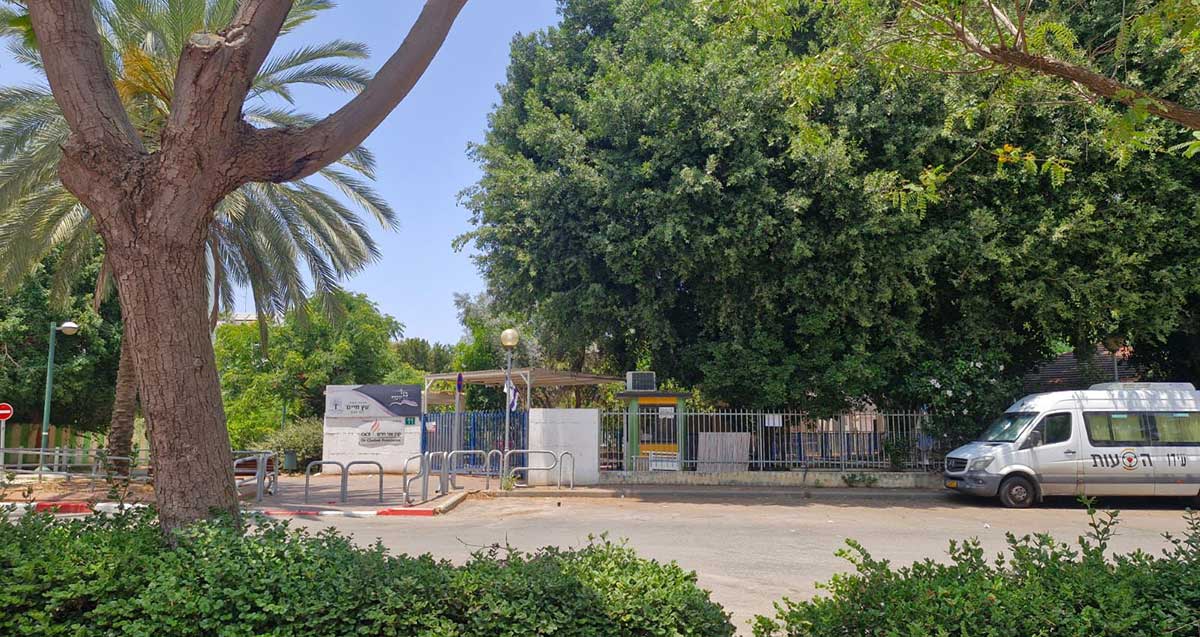 בית הספר עץ החיים של ש"ס בשכונת סביוני הכפר בכפר סבא. תמונה של הגדר סביב בית הספר וכניסה מהרחוב. מבנה בית הספר מוסתר על ידי עץ ענק. בכביש ליד בית הספר חונה רכב הסעות.