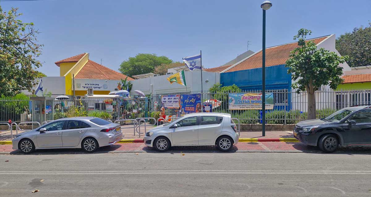 בית הספר מרדכי סורקיס בשכונת סביוני הכפר בכפר סבא. רצף מבנים של קומה או שתיים עם גגות רעפים אדומים. גדר מתכת מסביב. מכוניות חונות לפני בית הספר. על בית הספר שילוט: בית חינוך ע"ש "מרדכי סורקיס".