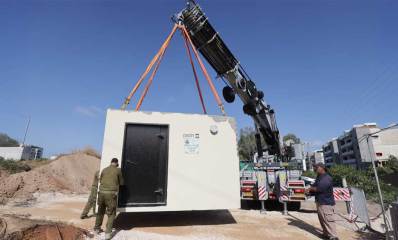 הצבת מיגונית יבילה מסוג ארבל בעיר עם מכונית מנוף.
