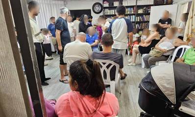 תושבים במקלט בהרצליה. המקלט צפוף ועמוס בספריות עם ספרי קודש