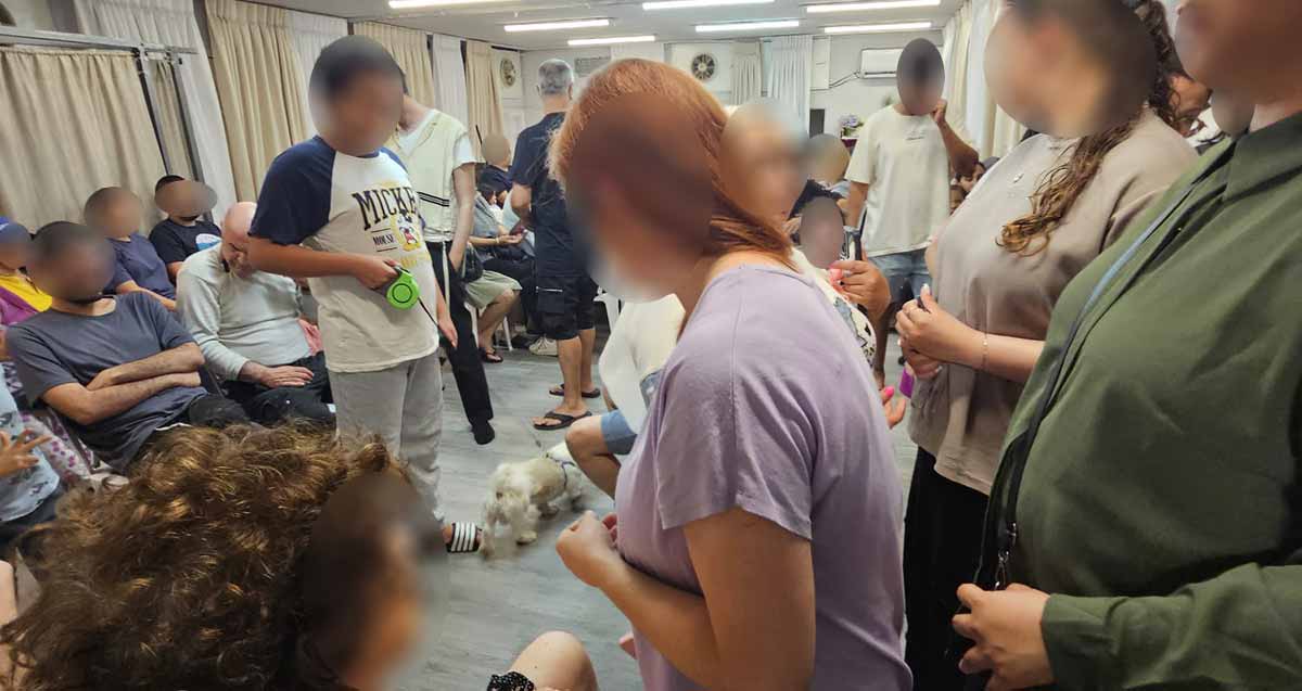 תושבים במקלט בהרצליה. המקלט צפוף ועמוס בספריות עם ספרי קודש
