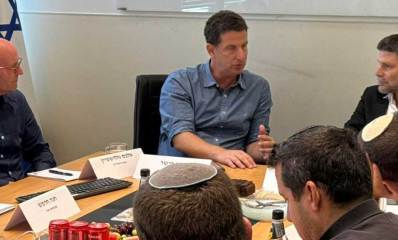 בצלאל סמוטריץ ויריב פישר יושבים בראש השולחן ואנשים נוספים בשני צידי השולחן. על השולחן פחיות קולה ופירות.