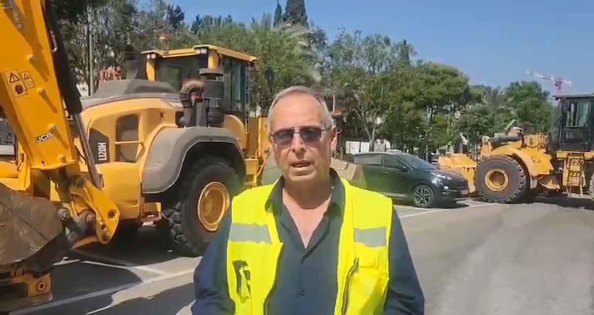 איציק רוכברגר, ראש העיר של רמת השרון עומד עם ווסט זוהר באמצע כביש. מאחוריו טרקטורים של JCB
