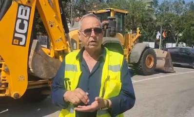 איציק רוכברגר, ראש העיר של רמת השרון עומד עם ווסט זוהר באמצע כביש. מאחוריו טרקטורים של JCB