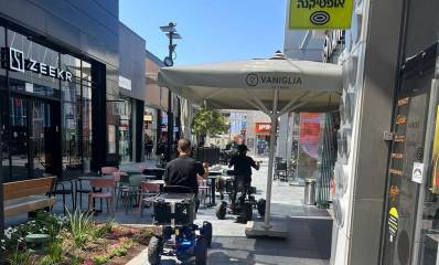 ביג פאשן גלילות. שתי שורות של חנויות בשתי קומות וביניהן רחבה לא מקורה עם גינות, שולחנות, כיסאות וספסלים.