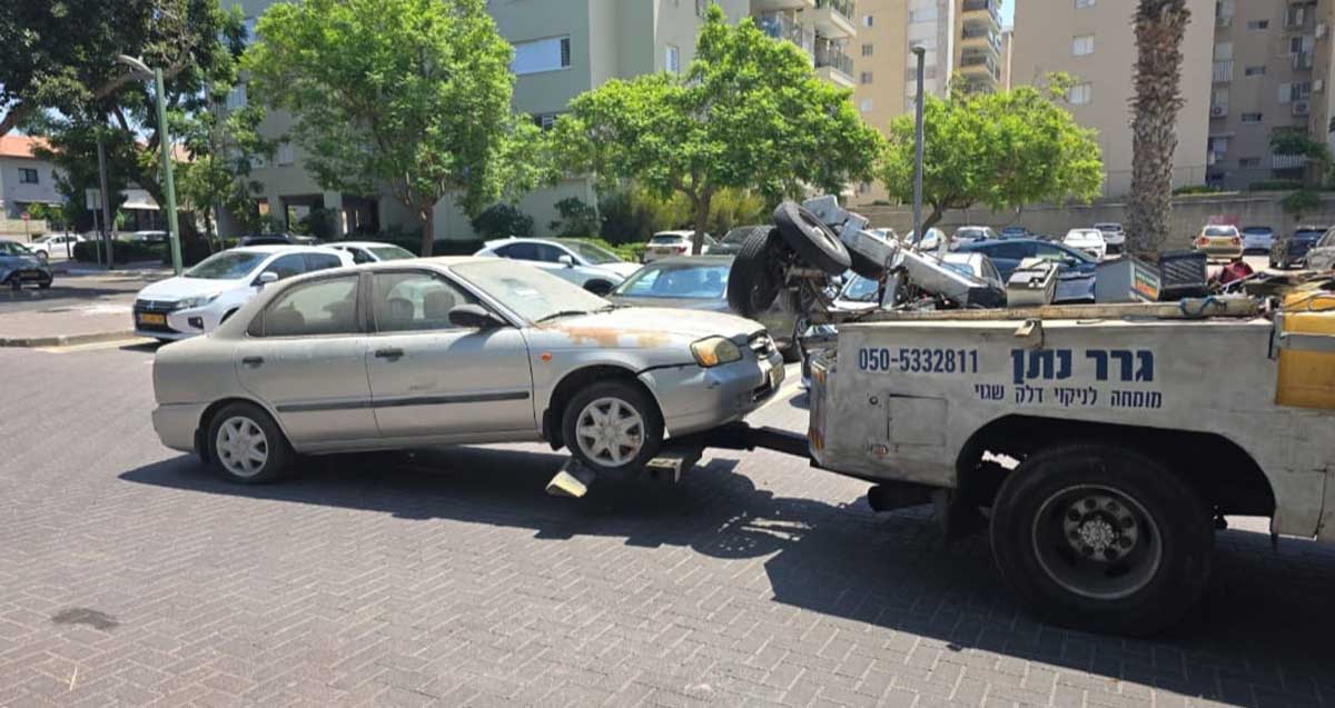 עיריית הרצליה מפנה רכבים נטושים. מכונית גרר גוררת רכב פרטי. על מכונית הגרר כיתוב: גרר נתן