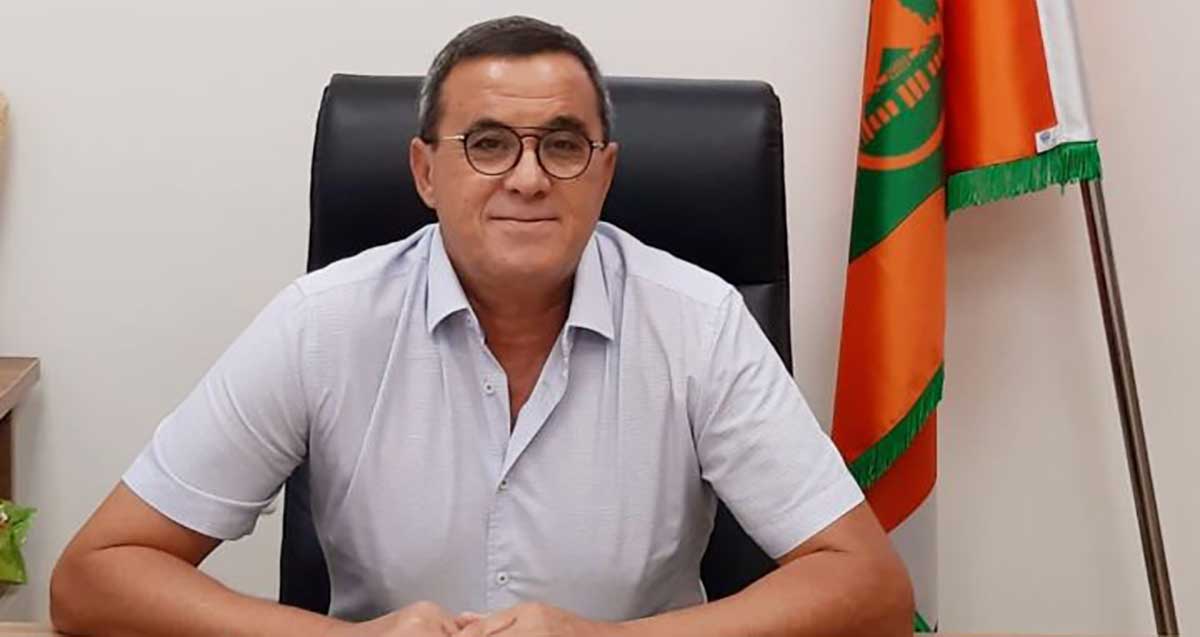 סגן וממלא מקום ראש עיריית כפר סבא דני הרוש מאחוריו דגל העיר