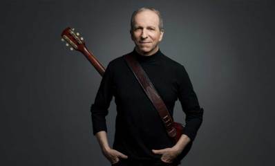 דני סנדרסון עם גיטרה על הגב.