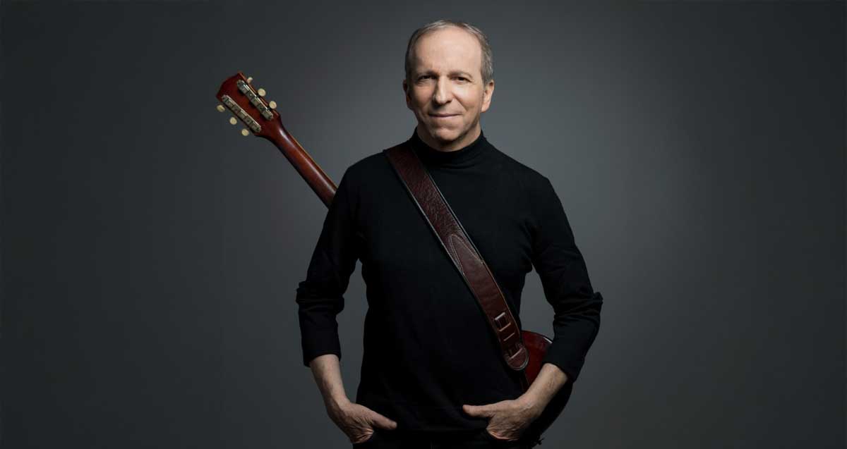 דני סנדרסון עם גיטרה על הגב.