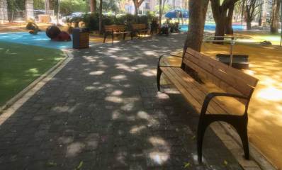 גינת הקוצר ברמת השרון. רחבה עם דשא. רחבה עם פסלים לילדים. רחבה עם משטח חול. ספסלים מעץ לאורך השביל, ועצים גדולים המשליכים צל.