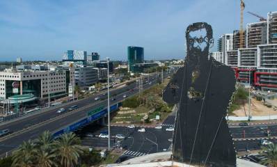 כביש החוף, צומת הסירה ואזור התעשיה הרצליה. תמונה של הרצל על מגדל מים.