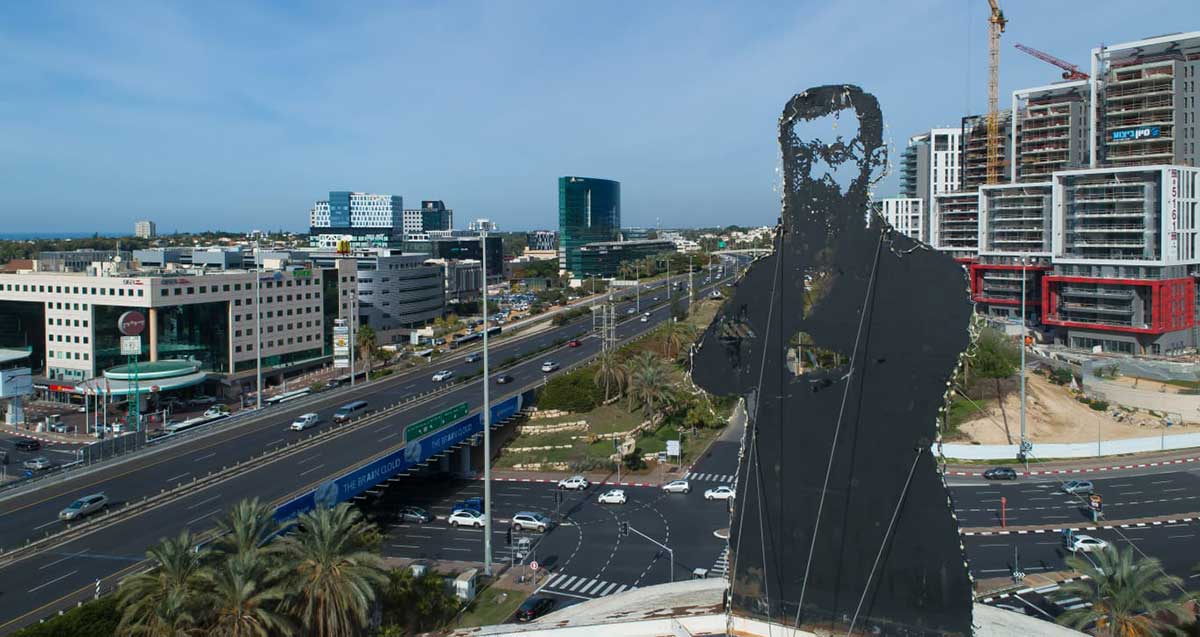 כביש החוף, צומת הסירה ואזור התעשיה הרצליה. תמונה של הרצל על מגדל מים.