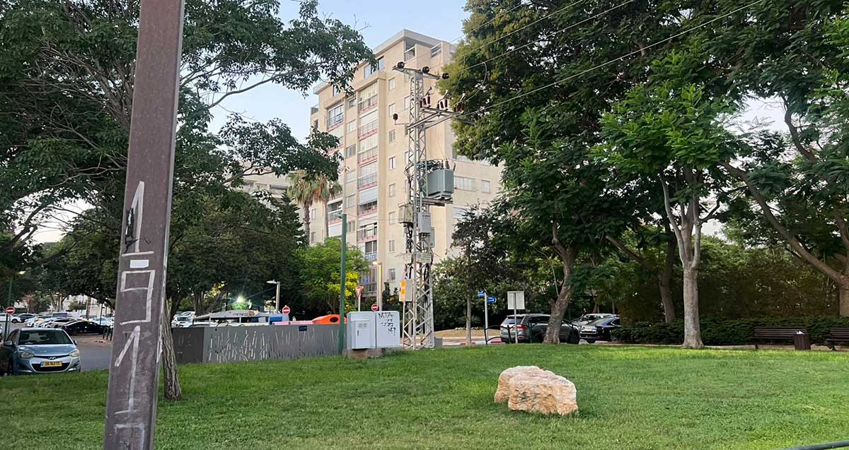 שכונת נווה אמירים בהרצליה. גינה ציבורית וברקע בניין של תשע קומות.