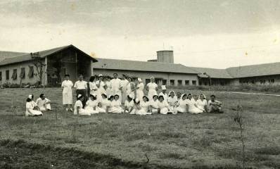 צוות בית היולדות יושבים ועומדים בתמונה קבוצתית לפני בית היולדות.