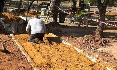 עבודות להנגשת הפוד טראק בשכונת נווה זמר ברעננה. פועל מפזר חול על שביל גישה.