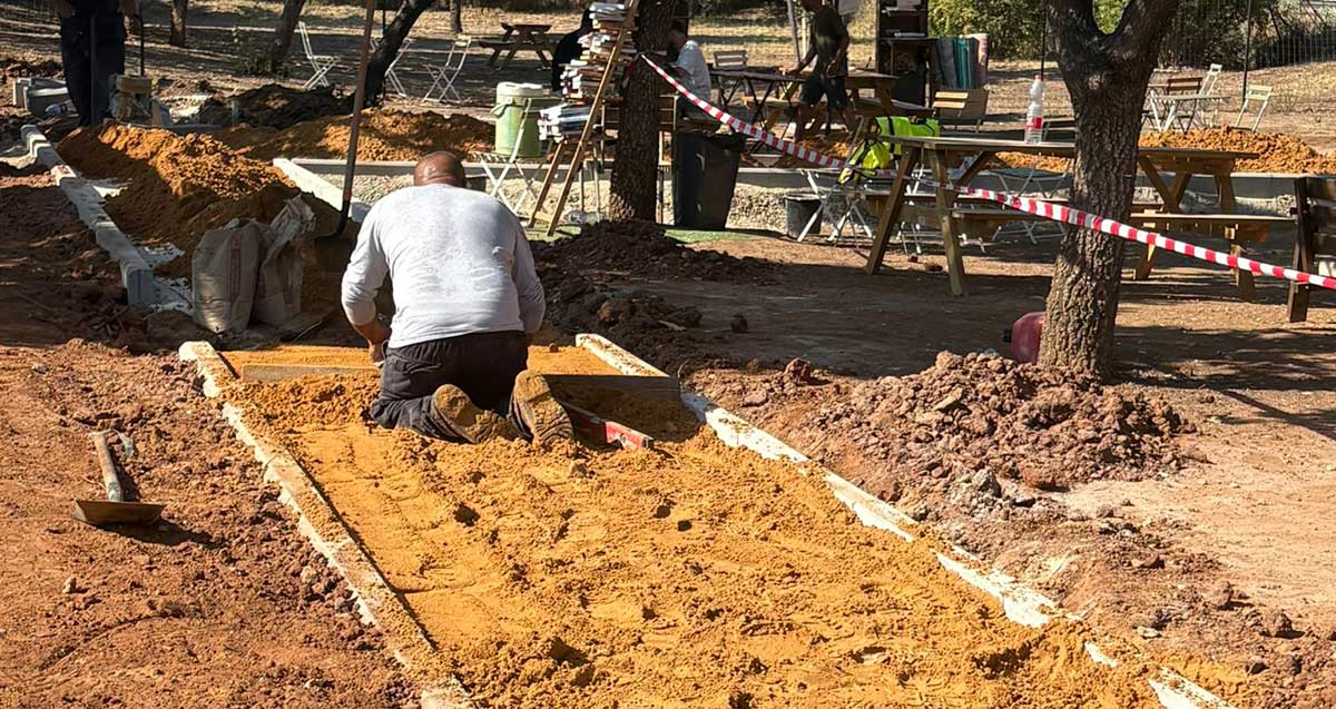 עבודות להנגשת הפוד טראק בשכונת נווה זמר ברעננה. פועל מפזר חול על שביל גישה.