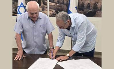 איציק רןכברגר ראש העיר רמת השרון חותם על מסמכים לידו מתבונן השר חיים כץ