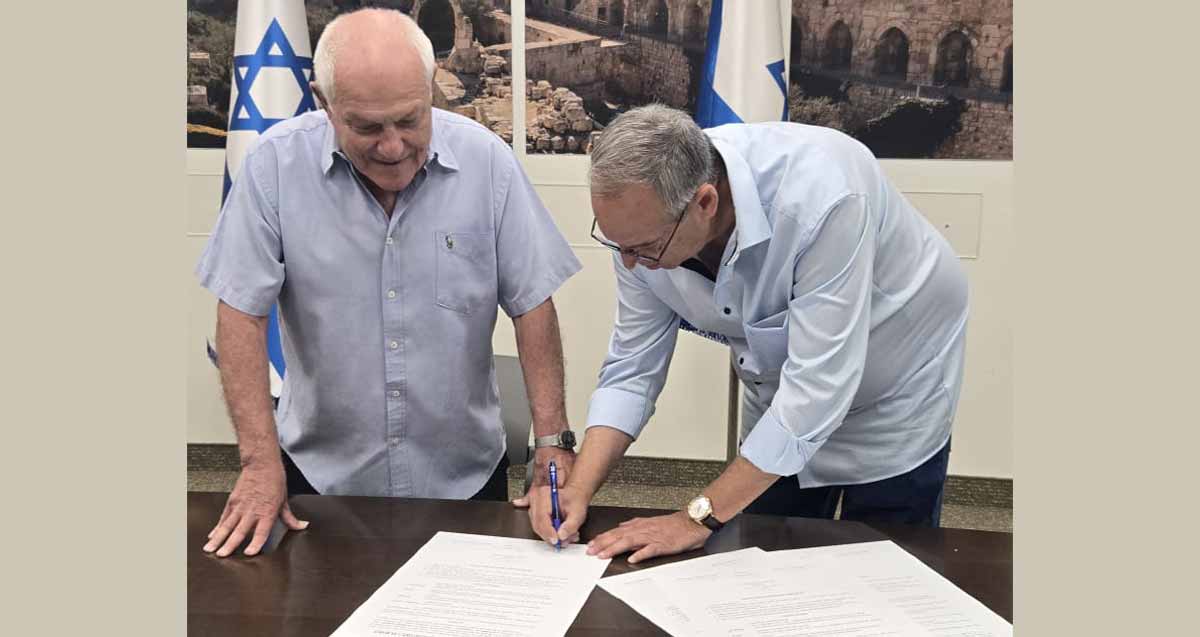 איציק רןכברגר ראש העיר רמת השרון חותם על מסמכים לידו מתבונן השר חיים כץ