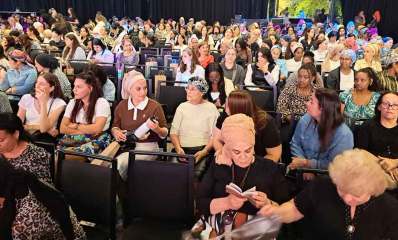 הכנס של תנועת אמונה. נשים יושבות בשורות באולם גדול.