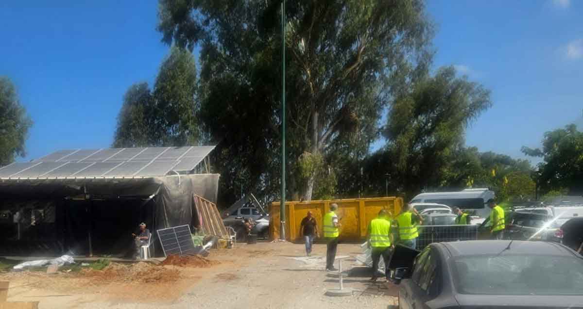 ביצוע צו הריסה של בנייה לא חוקית בעסק מזון בכניסה לבסיסי המודיעין. פועלים בבגד עליון צהוב ליד העסק.