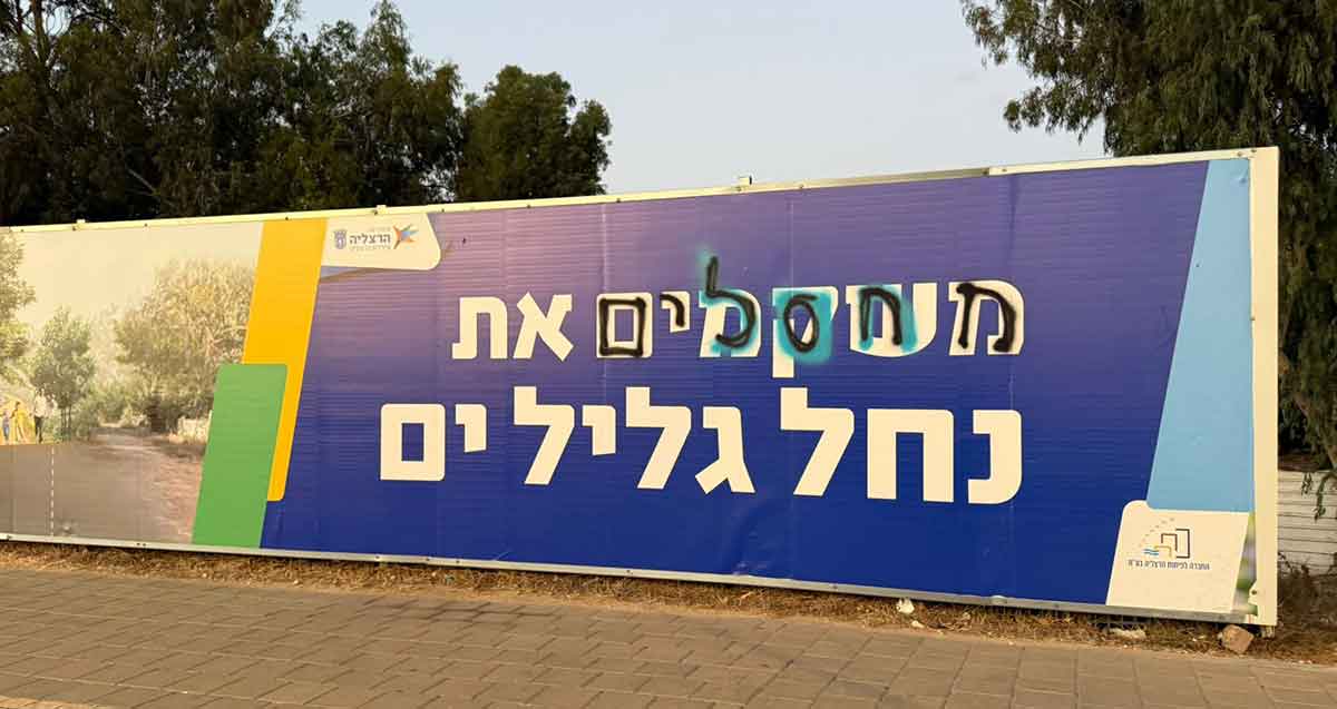 מחאה בהרצליה סביב הכוונה לכרות 13 אקליפטוסים בנחל גליל ים. שלט של עיריית הרצליה בכיתוב: משקמים את נחל גליל ים. על המילה משקמים רשום בשחור: מחסלים