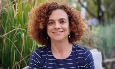 תמונת פנים של חני סימפסון יושבת מאחורי שיחים