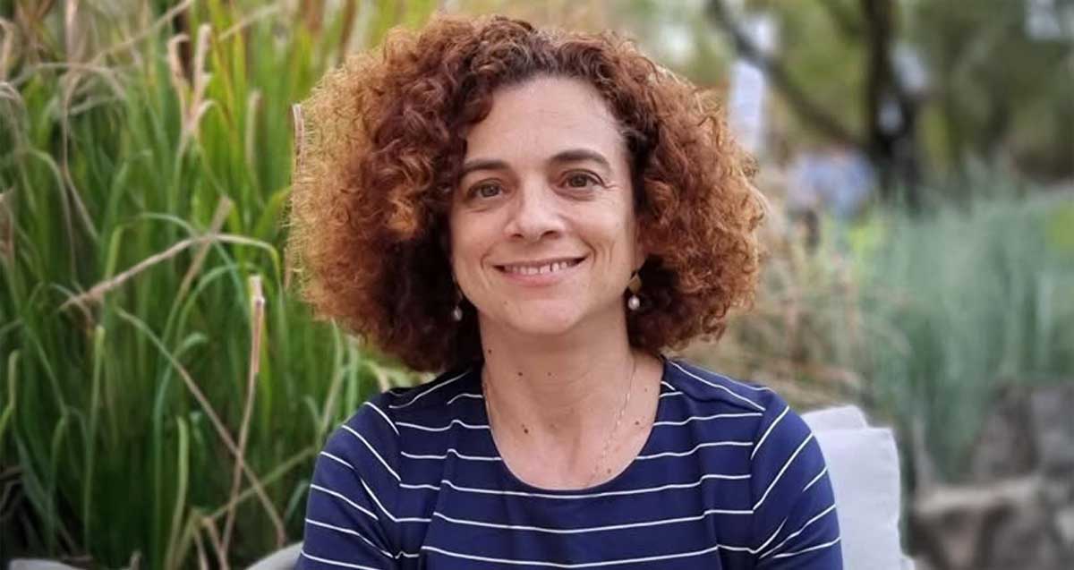 תמונת פנים של חני סימפסון יושבת מאחורי שיחים