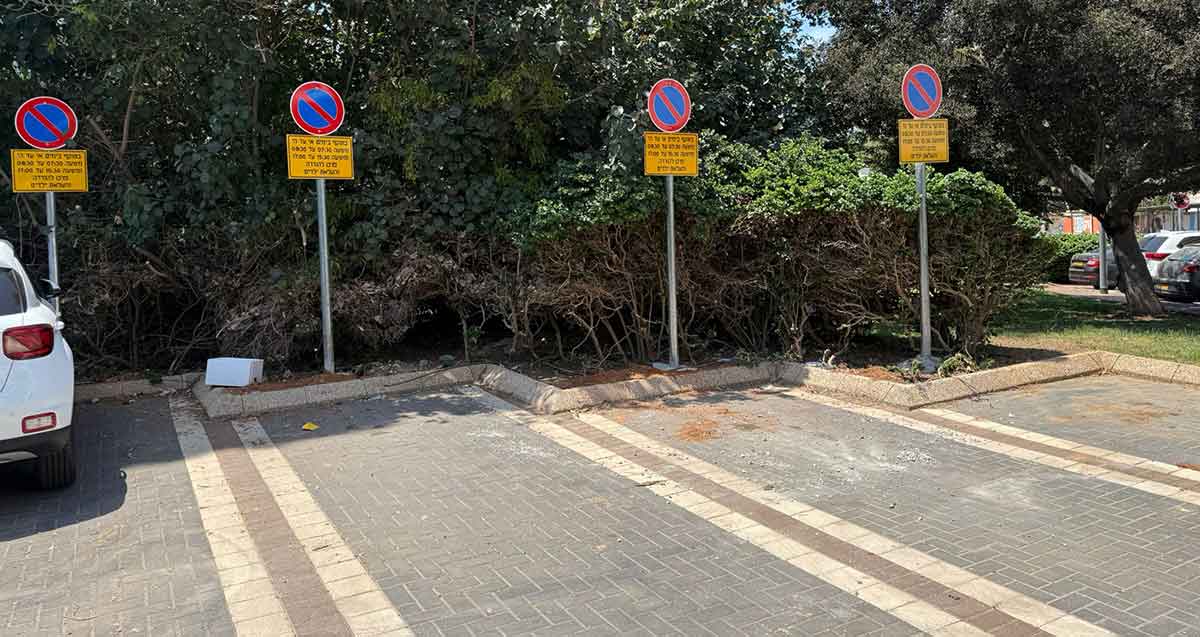 חניות להורדת ילדים בגן ברחוב עולי בבל הרצליה. שורה של חניות עם שלט עגול של אין חנייה ומתחתיו פירוט השעות.