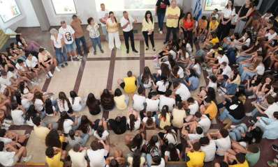 פתיחת שנת הלימודים בכפר סבא. התלמידים יושבים על הרצפה באולם, ומולם עומדים המורים.