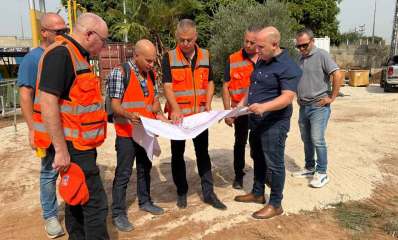 סער והצוות המקצועי בעתיר ידע עם חגור כתום מסתכלים במפה אותה אוחזים בידיים.