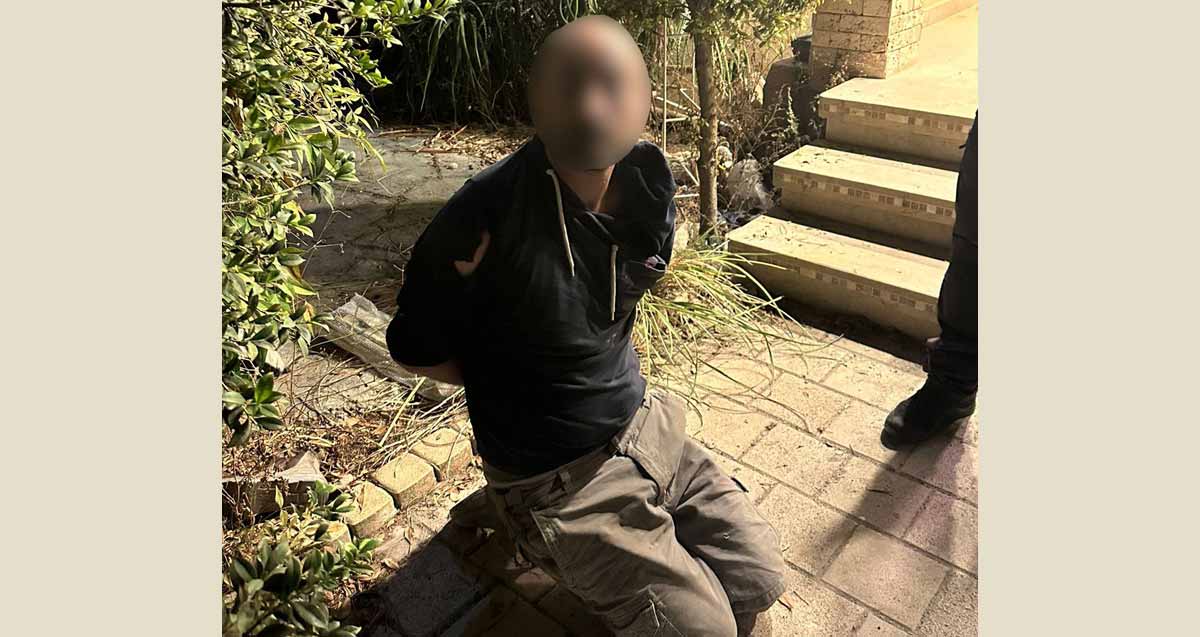 אדם אזוק כורע על ברכיו