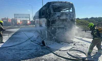 אוטובוס נשרף באיילון, כביש 20. אנשי כבאות והצלה עם זרנוקים מכבים את השריפה באוטובוס.
