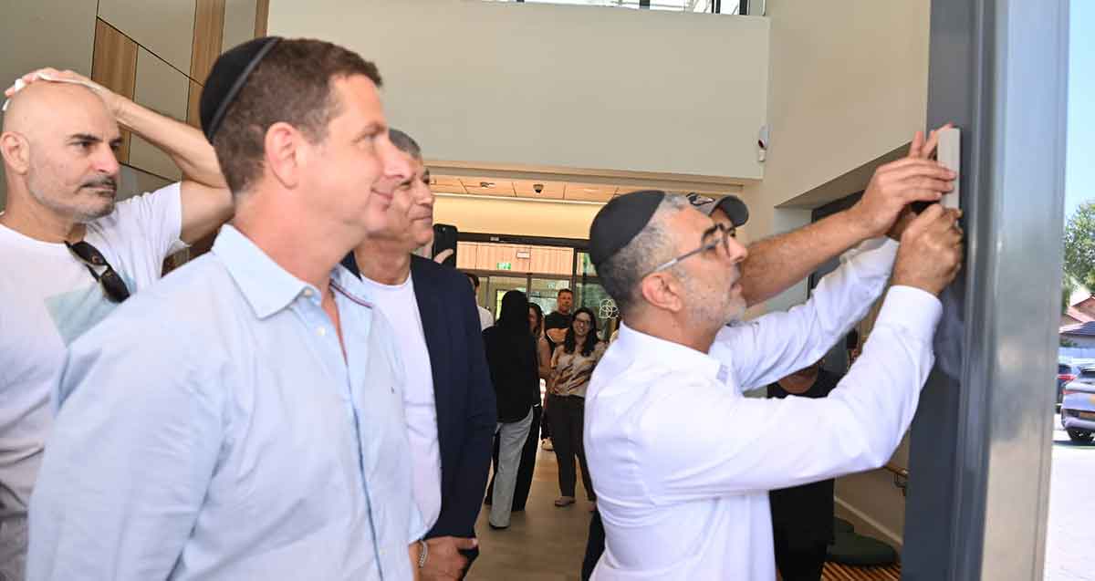 יריב פישר בקביעת מזוזה בבית אילן גילאון.