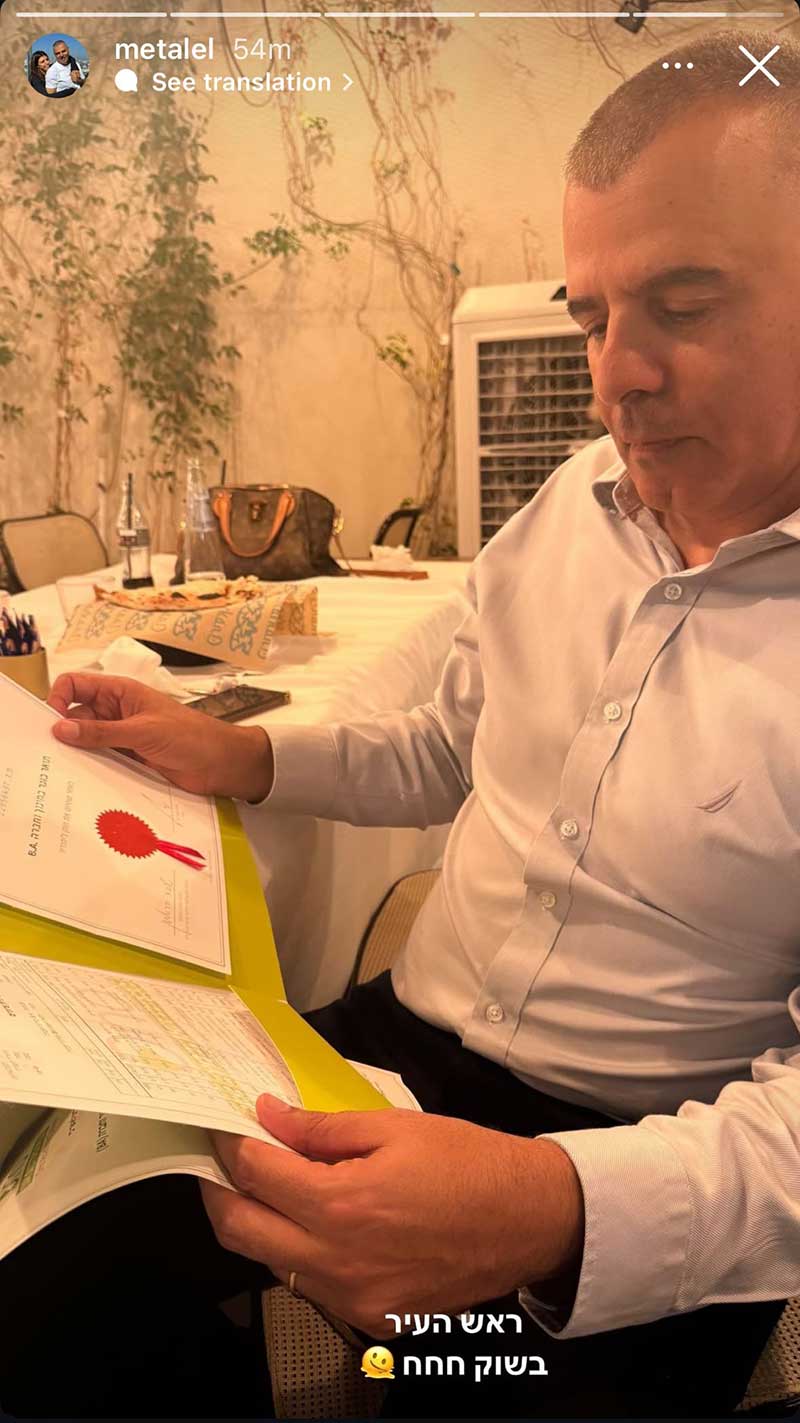 תמונה מתוך סטורי שבה נראה ראש העיר כפר סבא מתבונן בתעודת תואר ראשון