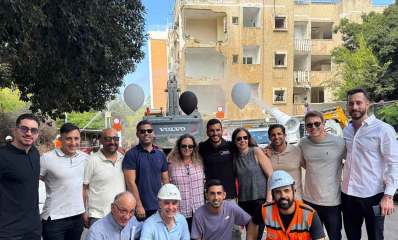 פרויקט התחדשות עירונית ברחוב סולץ 8 בהרצליה. צילום קבוצתי של בעלי דירות ועובדים של כלי הנדסי הורס את הקומות העליונות.