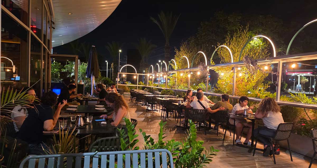 סועדים מסובים לשולחנותבמרפסת של מסעדת קינג גונג ברעננה