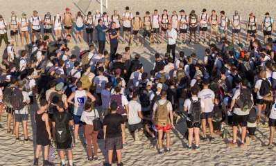 הכנה לגיוס בחוף הרצליה. הנערות והנערים עומדים במעגל ובמרכז שלושה מדריכים.