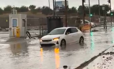 מכונית נודעת בתוך הצפה בכביש ליד צומת מרומזר