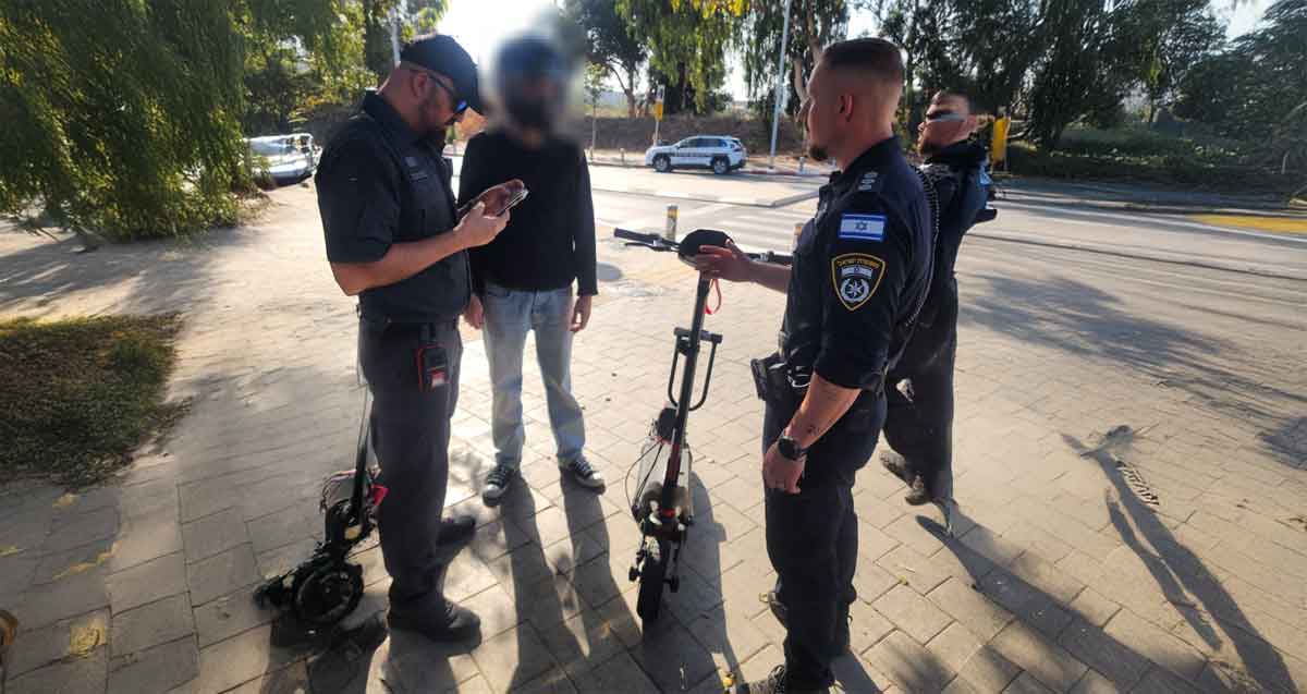 אכיפת דו גלגלי בהרצליה. שלושה שוטרים ורוכב קורקינט שפניו מטושטשים. לידם שני קורקינטים.