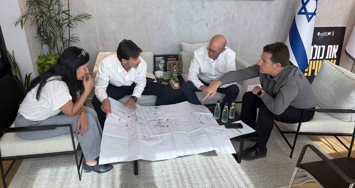יריב פישר ואלכס גולדשטיין ועוד אישה וגבר יושבים מסביב לשולחן ועליו מפה.