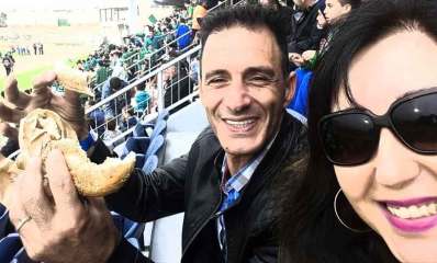 ציבי אלון יו"ר סניף הליכוד בכפר סבא, יושב במגרש כדורגל ואוחז ביד פרוסת לחם.