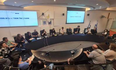 מפגש בין יריב פישר, סגניו ומנכל העירייה עם נציגי ההורים בחדר הישיבות בעיריית הרצליה. על המסכים התלויים על הקירות רשום אתג על אזורי - בית ספרי