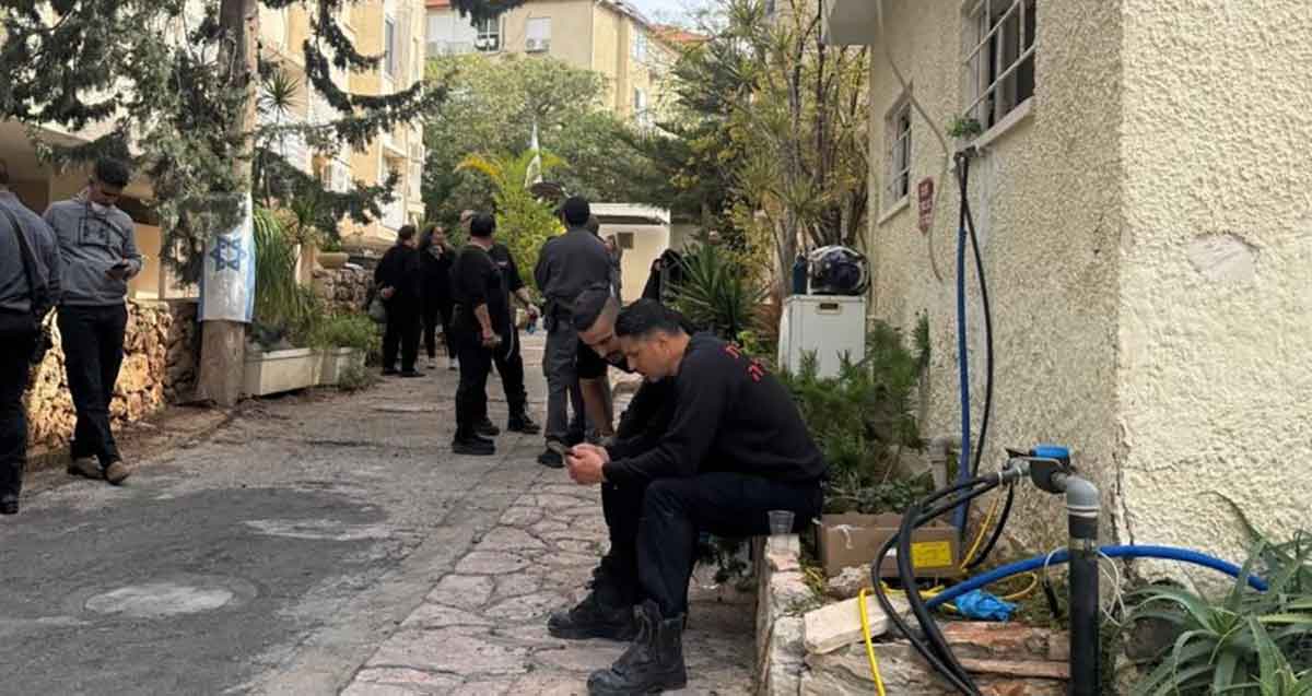 אנשי כבאות ומשטרה בהרצליה - שיפוצניקים. אנשים רבים בין שני בניינים.