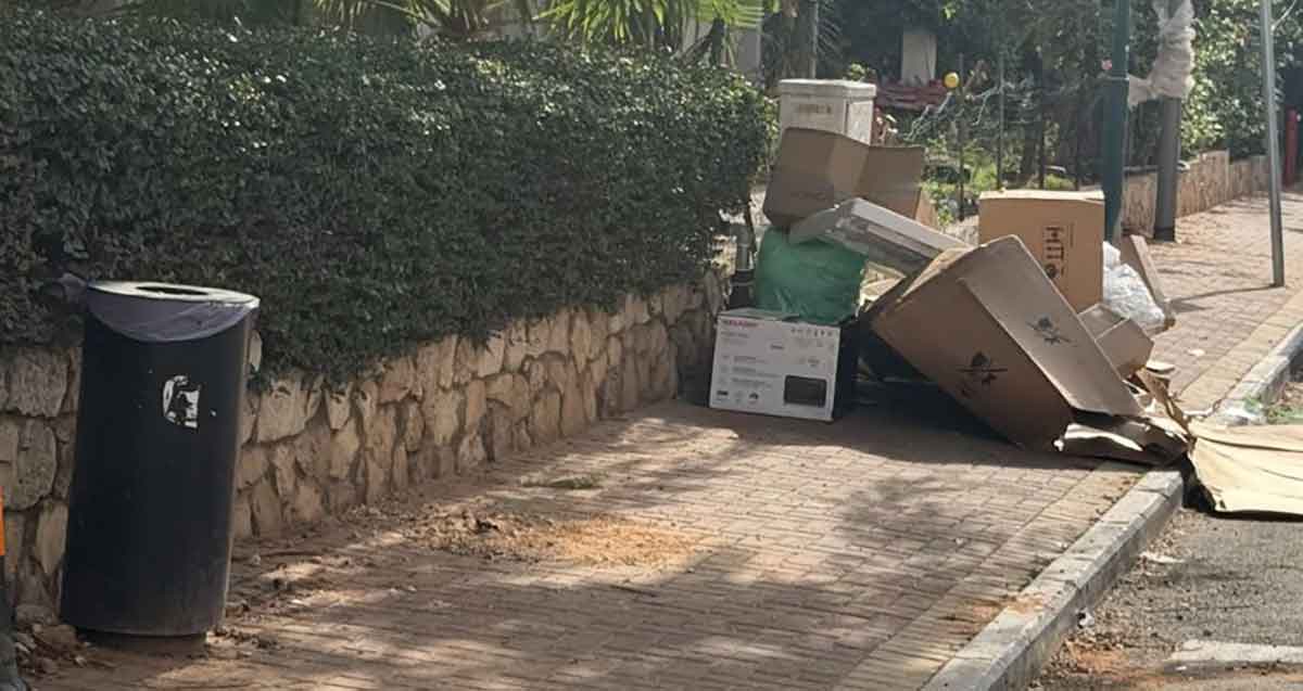 פסולת ברחוב גולומב רמת השרון. על המדרכה קרטונים גדולים.
