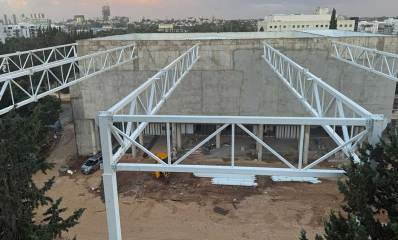 בניית גג והצללה לחצר החדשה של בית ספר הנדיב בהרצליה. באופק בנייני העיר ועצים