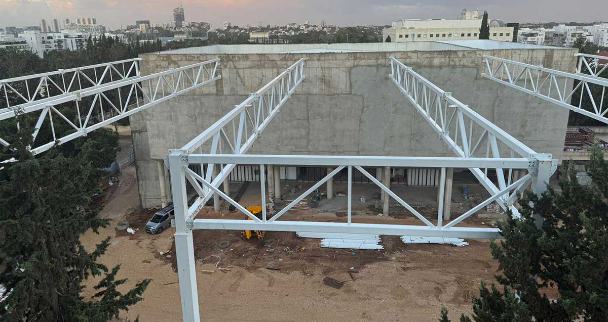 בניית גג והצללה לחצר החדשה של בית ספר הנדיב בהרצליה. באופק בנייני העיר ועצים