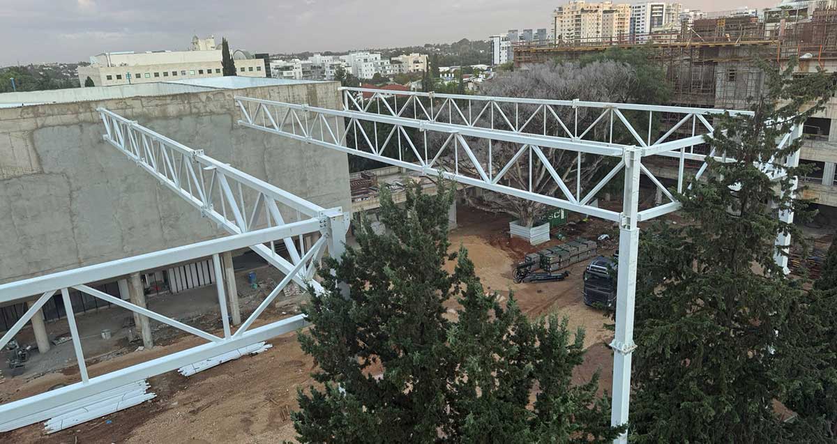 בניית גג והצללה לחצר החדשה של בית ספר הנדיב בהרצליה. באופק בנייני העיר ועצים