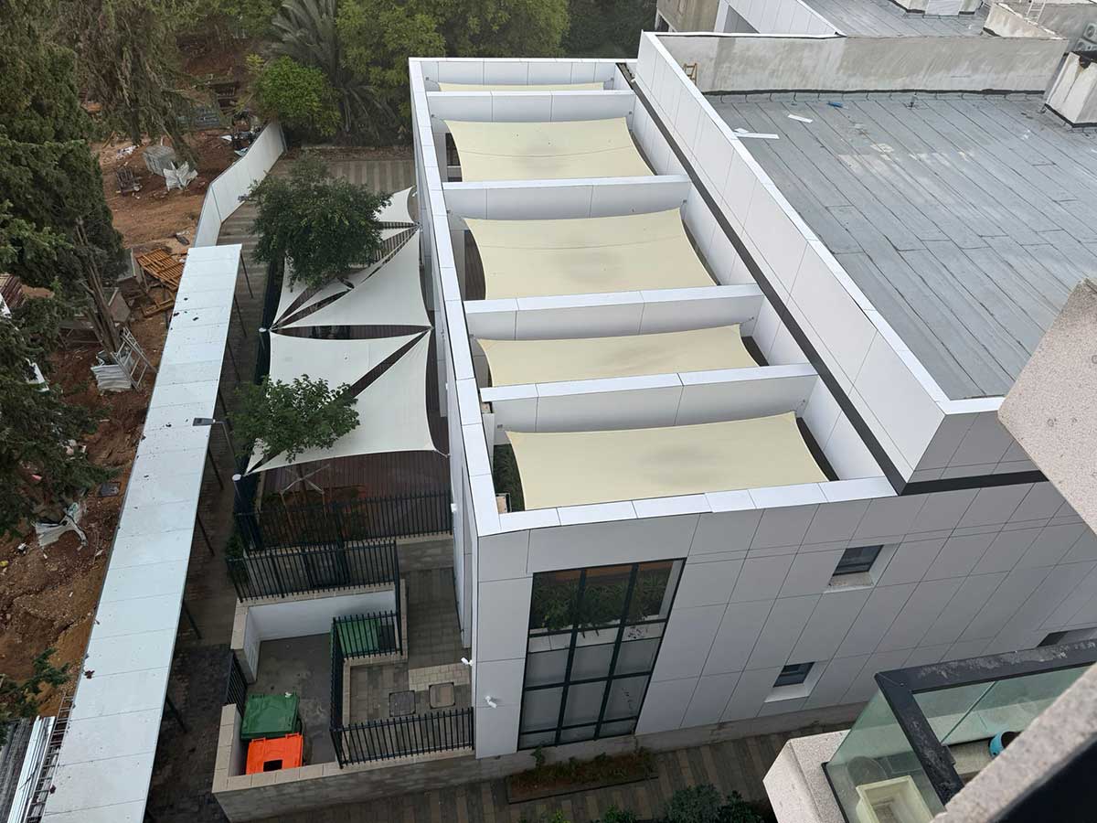 מתחם גני הילדים הנדיב, מבט מבניין סמוך שבו רואים את הקרבה למרפסות הדיירים